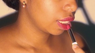 Sexy lips ebony playing with her red lipstick in close up